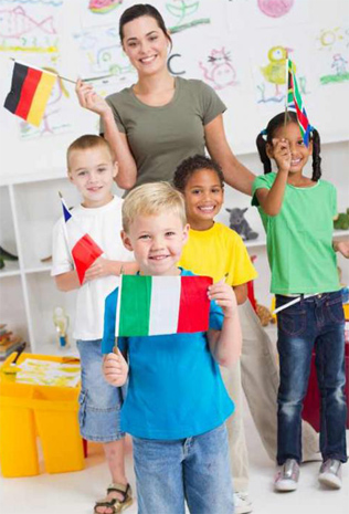 A cute young boy holding italian flag in classroom with classmates and teacher with diverse flags
